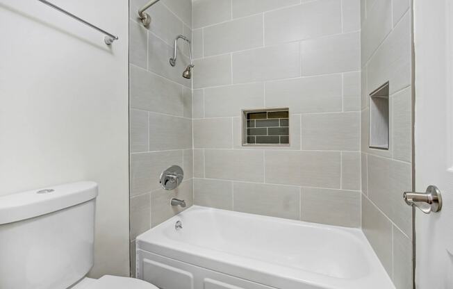 a white bathroom with a shower and a toilet