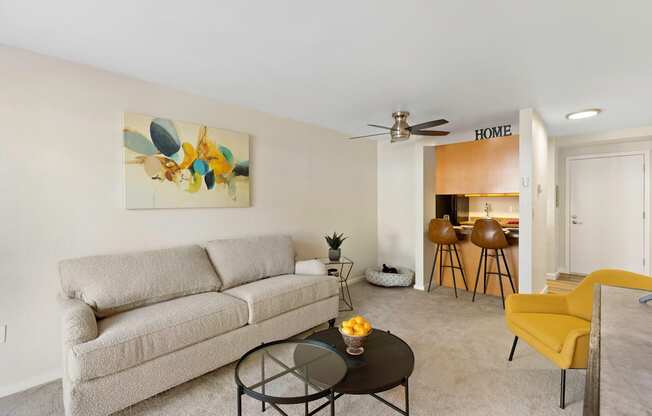 a living room with a couch a table and a ceiling fan