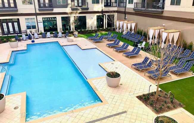 a large swimming pool with lounge chairs around it