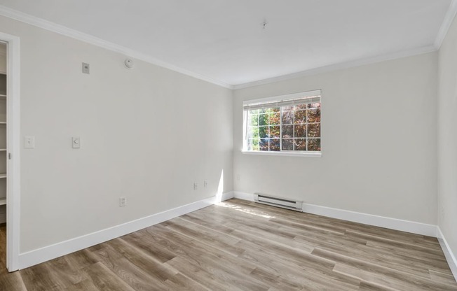 a bedroom with white walls and a window