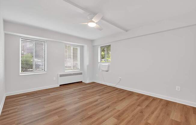 A room with wooden flooring and white walls.