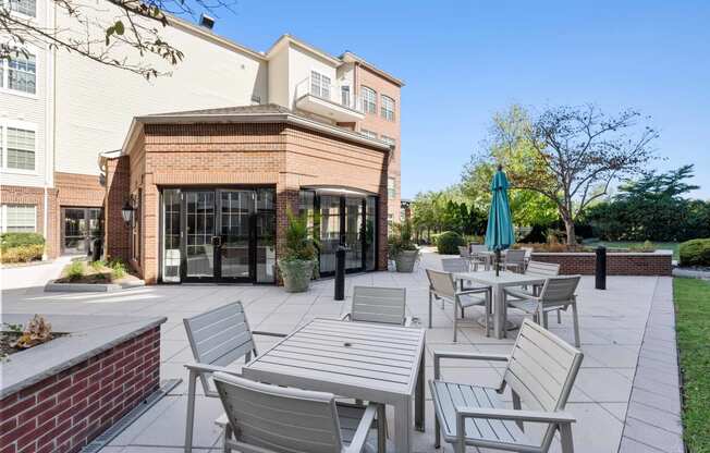 a patio with tables and chairs in front of a brick building  at The Lena, Raritan, 08869