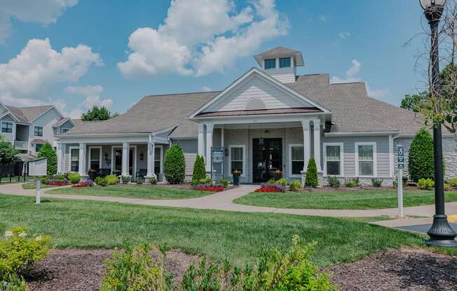 A white house with a grey roof and a small tower on the roof.