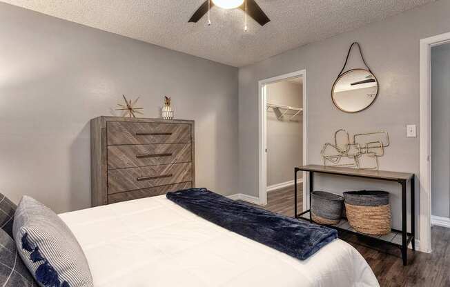 A bedroom with a bed, dresser, and mirror.