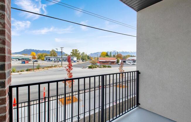 a balcony with a view of a parking lot and mountains