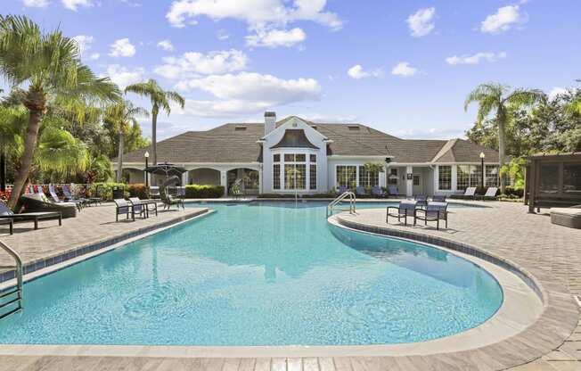 a large swimming pool with a house in the background