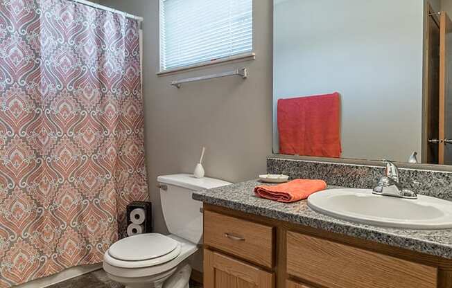 Tiled bathroom with bathtub and granite countertop at Skyline View Apartments in Lincoln NE