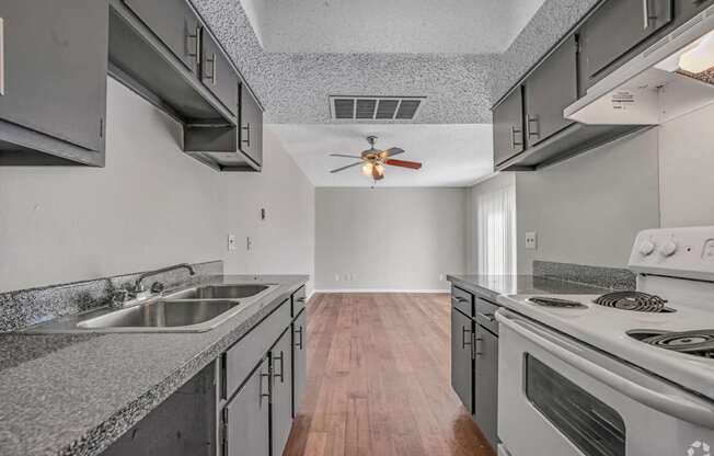 A modern kitchen with a stainless steel sink and stove.