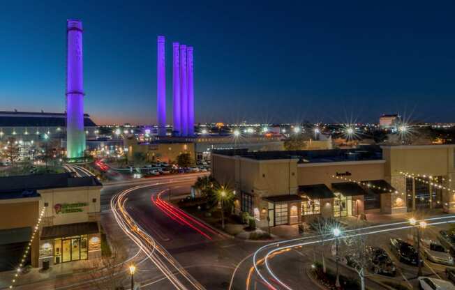 a city at night with purple towers in the background