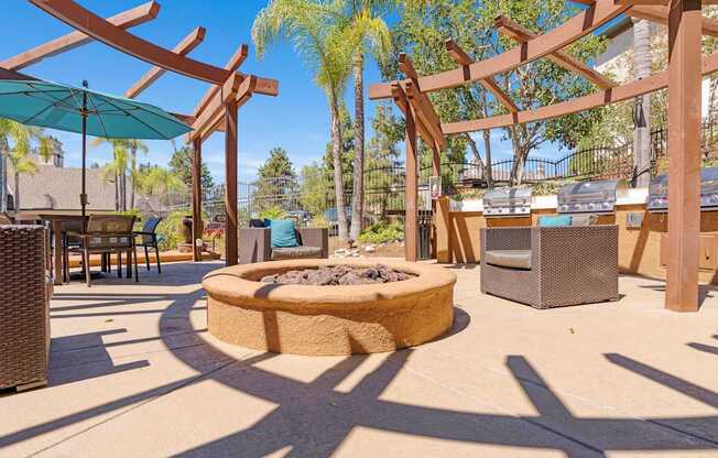 A patio with a fire pit and seating area.