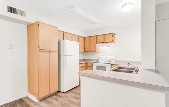 a kitchen with white appliances and wooden cabinets