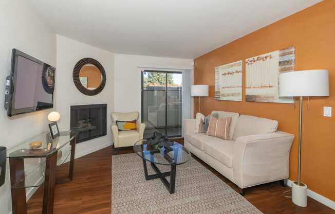 a living room with a couch and a glass coffee table and a fireplace at Rocklin Manor  Apartments, Rocklin  , California