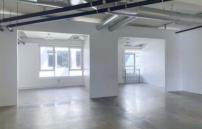 A large empty room with a window and a door.