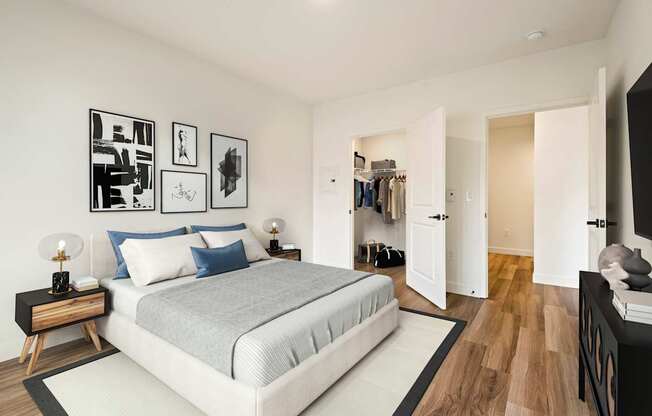 A bedroom with a large bed and a wooden floor.
