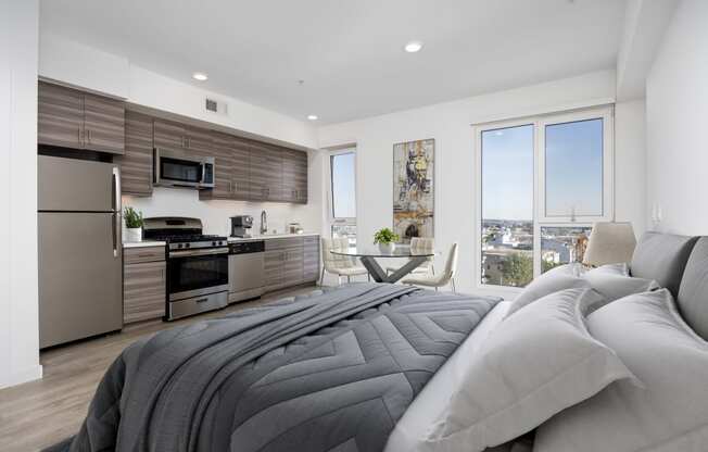 a bedroom with a bed and a kitchen with stainless steel appliances