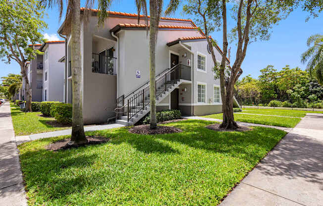 A building with a red tile roof and a staircase leading to the entrance.
