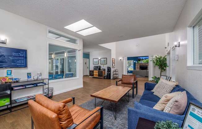 A living room with a blue couch and a brown leather chair.