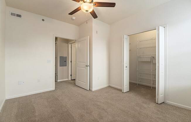 A bedroom with a ceiling fan and walk-in closet at Lynbrook Apartments and Townhomes, Elkhorn, NE, 68022