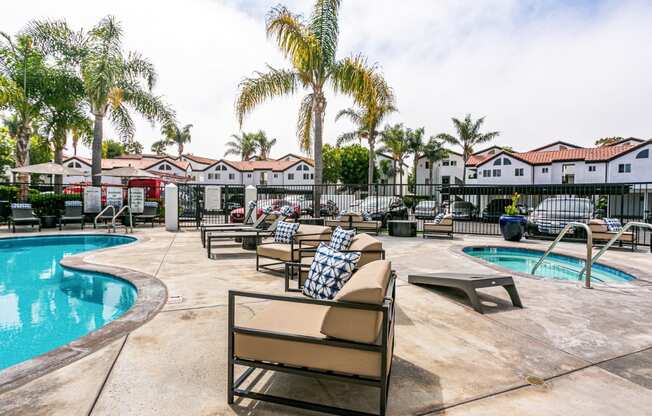 a resort style pool with chairs and palm trees