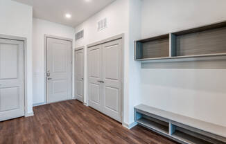 A room with three doors and a window with blinds.