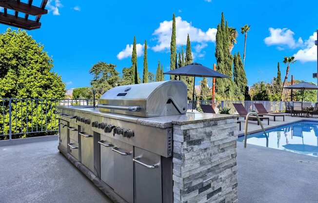 A modern outdoor kitchen with a grill and sink.