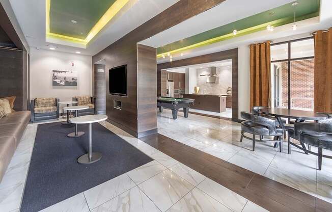 a rendering of a lobby with tables and chairs and a television at The Hendrix, Atlanta, GA, 30329