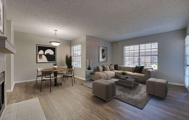 A living room with a grey couch, a coffee table, and a dining table with chairs.