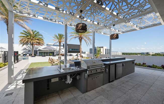 a stainless steel outdoor kitchen with a roof terrace and palm trees