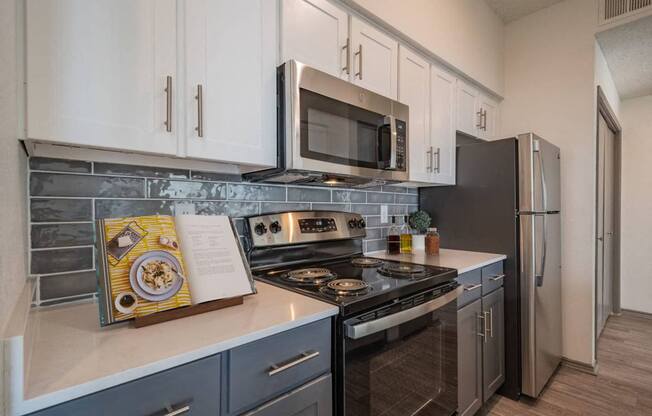 a kitchen with stainless steel appliances and white cabinets