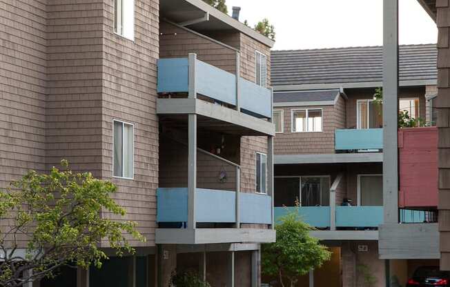 a view of two buildings with balconies and a courtyard