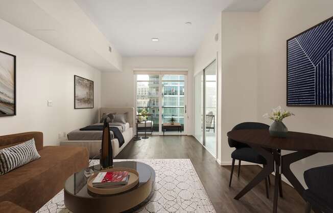 A modern living room with a brown couch, a coffee table, and a large window.