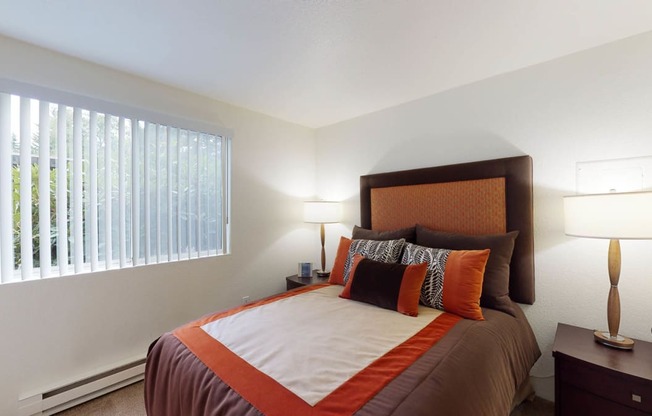 Bedroom with cozy bed and window at North Creek Apartments, Everett, WA