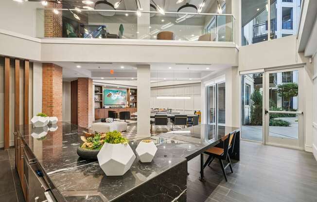 A modern kitchen with a marble countertop and a glass balcony.