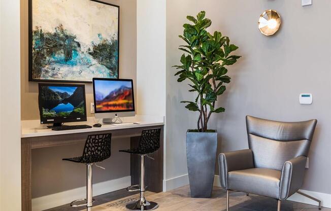 a desk with two computers and a chair in a room