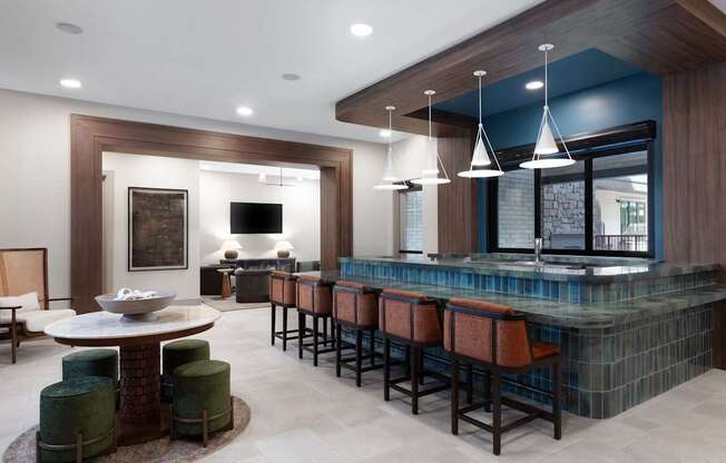 A modern bar area with a round table and bar stools.