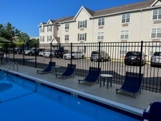 a swimming pool with a table and chairs next to a building