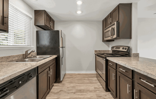 a kitchen with stainless steel appliances and marble counter tops