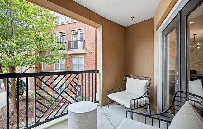 A balcony with a white chair and a black railing.