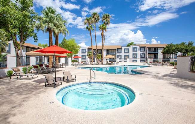 a resort style pool with palm trees and a building in the background