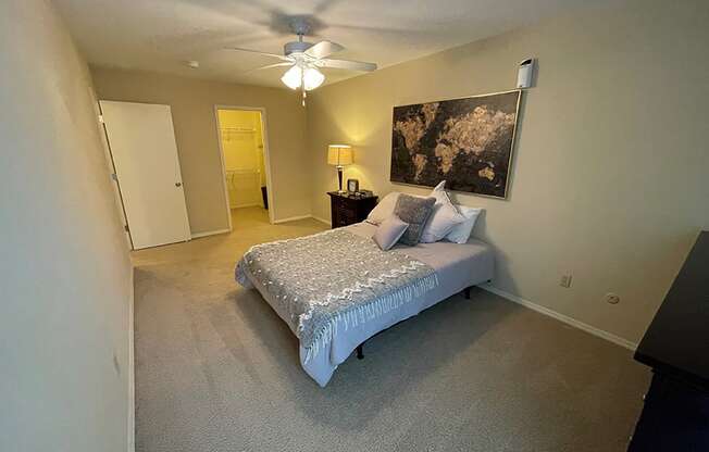 a bedroom with a bed and a ceiling fan