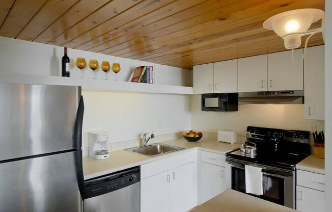 a kitchen with white cabinets and a stainless steel refrigerator at Tindeco Wharf, Baltimore