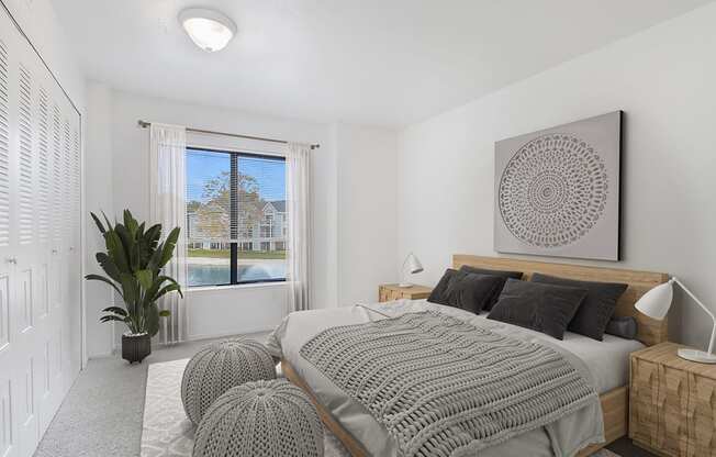 A bedroom with a large bed and a large window with a view at North Pointe Apartments, Elkhart