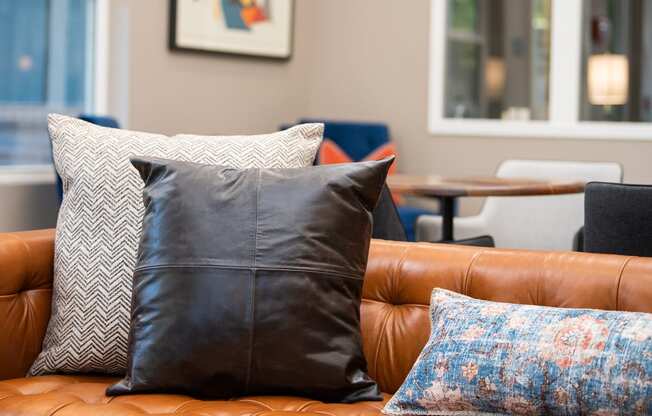 a leather couch with pillows and a coffee table in the background