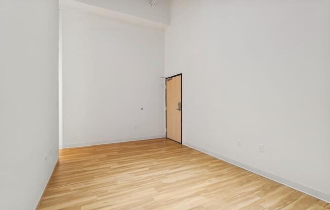 A room with a wooden floor and a door.