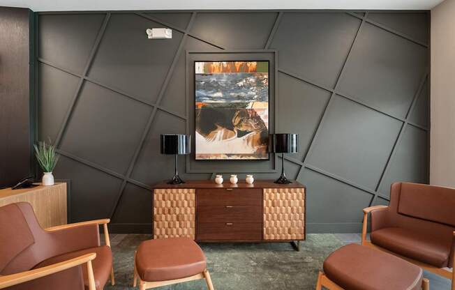 A room with a brown chair, a brown cabinet, and a painting on the wall.