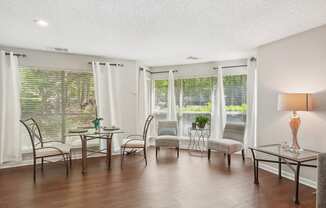A room with a table, chairs, and a lamp.