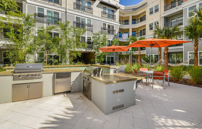 a patio with several stainless steel appliances and a building