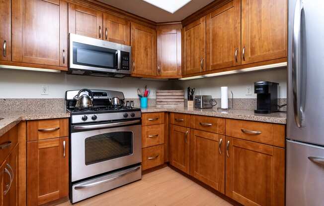 a kitchen with wood cabinets and stainless steel appliances