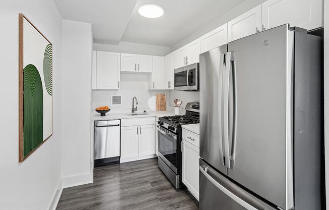 a kitchen with stainless steel appliances and white cabinets