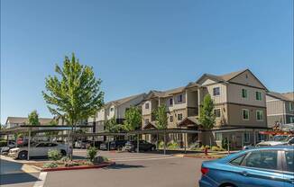 A blue car is parked in a parking lot in front of a building at Forestplace Apartment Homes, Oregon, 97116